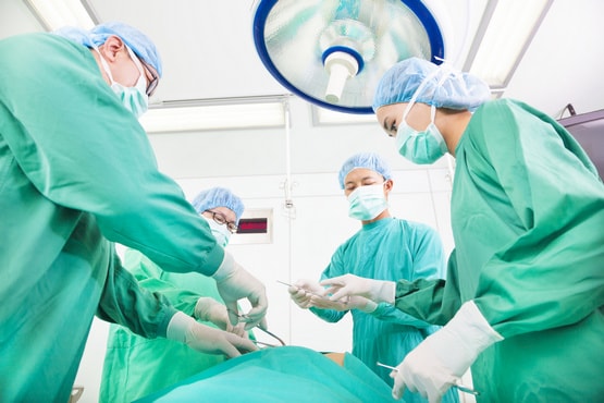 Surgeons operating on patient with neck tumor